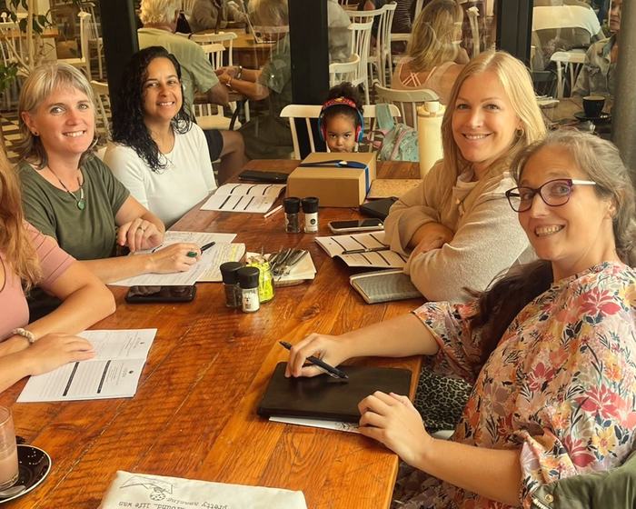 Moms working through their workbooks together over coffee