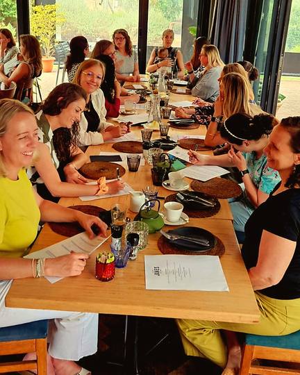 Moms working through their workbooks at a long table