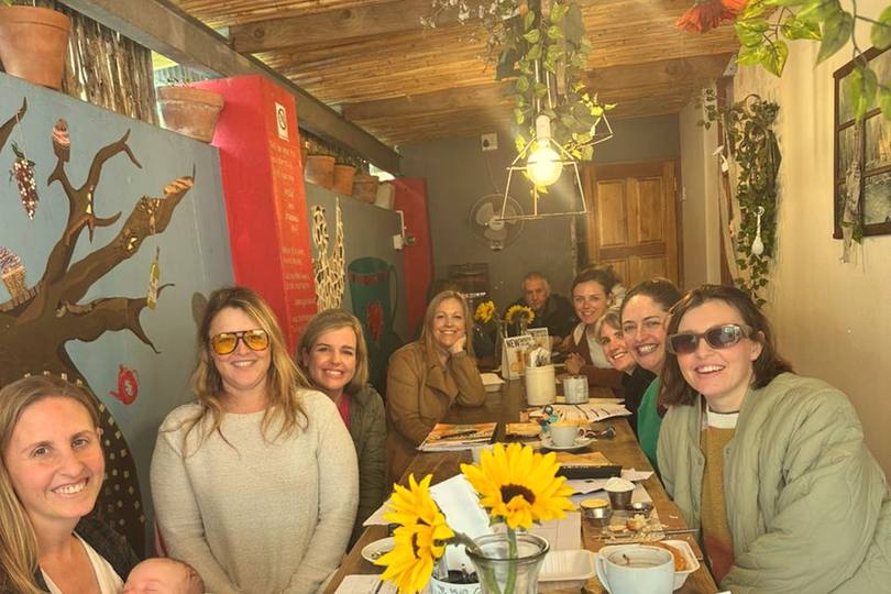 A pod meetup around a table with sunflowers